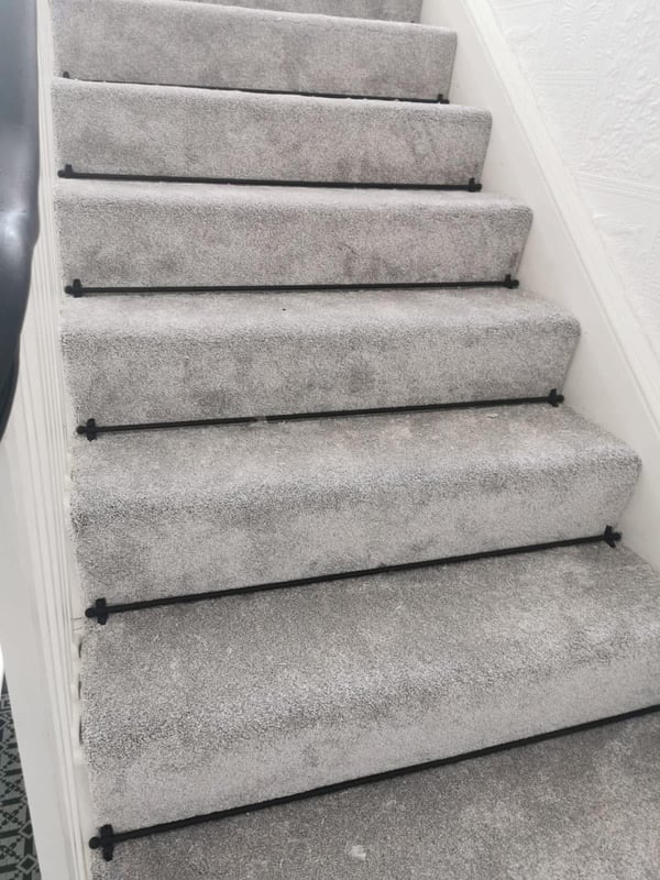 Grey stair carpet with black rods