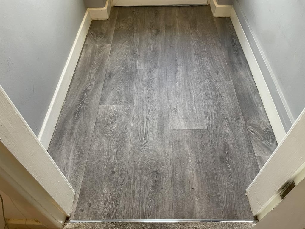 Grey wood-effect vinyl flooring fitted in a hallway