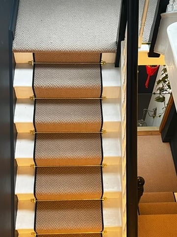 Brass rod runner on dark staircase